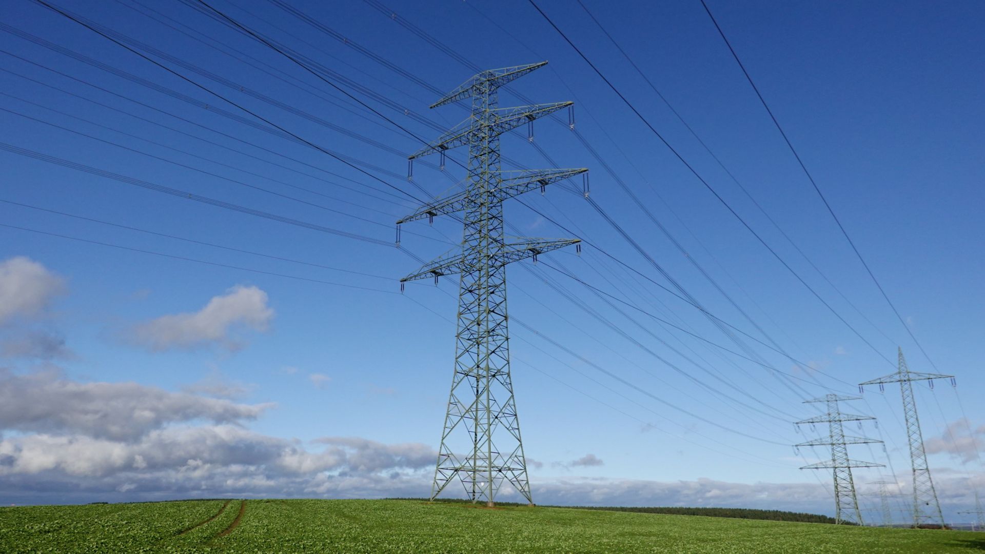 Ein Strommasten auf einem Feld.