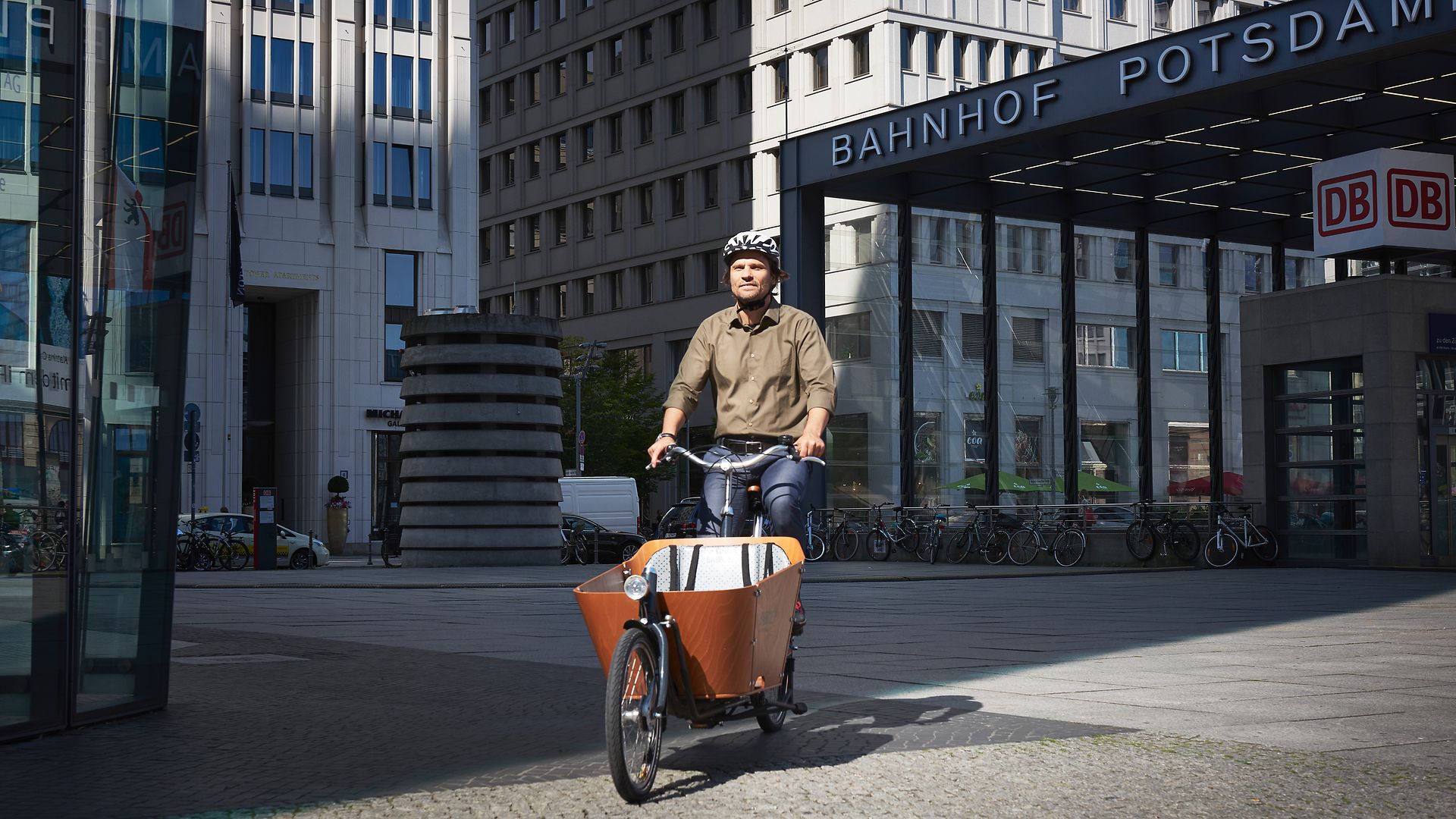 Ein Mitarbeiter fährt mit dem DB-Firmenrad über den Potsdamer Platz zur Arbeit.