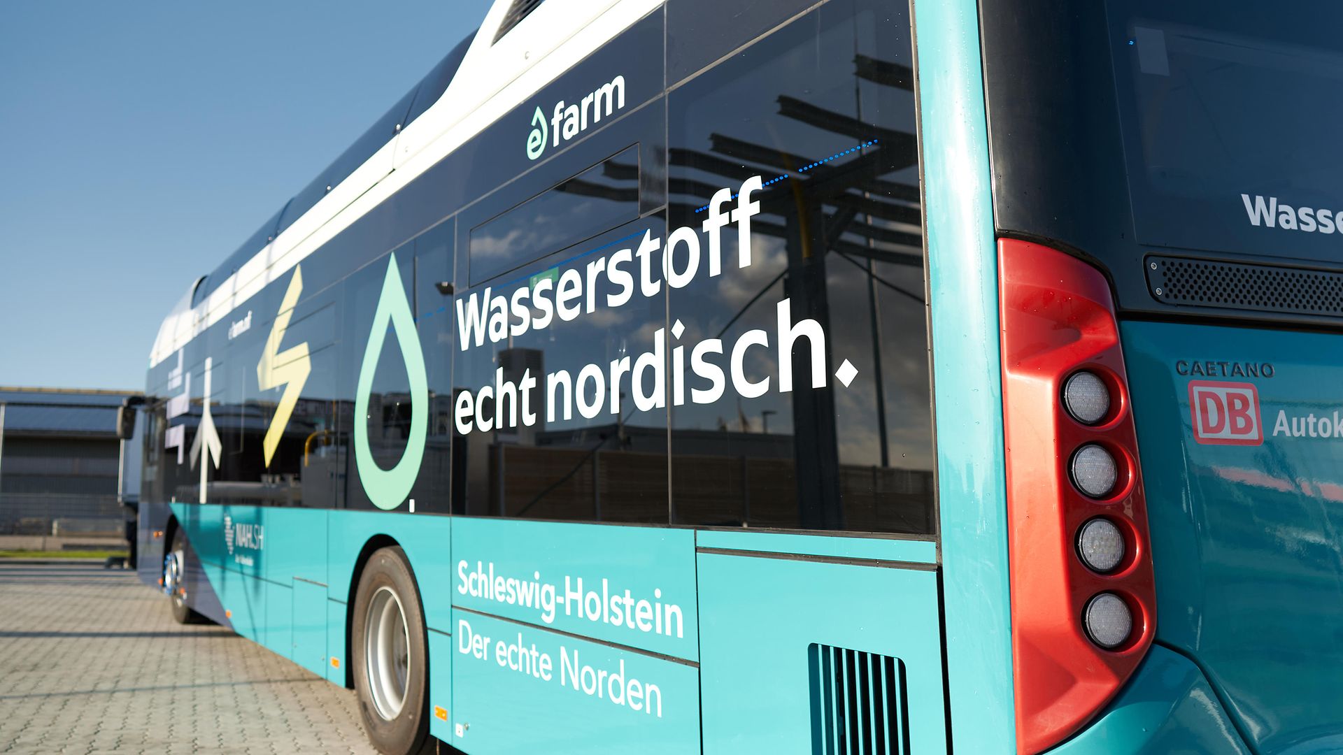 Ein türkiser Wasserstoffbus mit der Aufschrift Wasserstoff echt nordisch und dem Logo eFarm