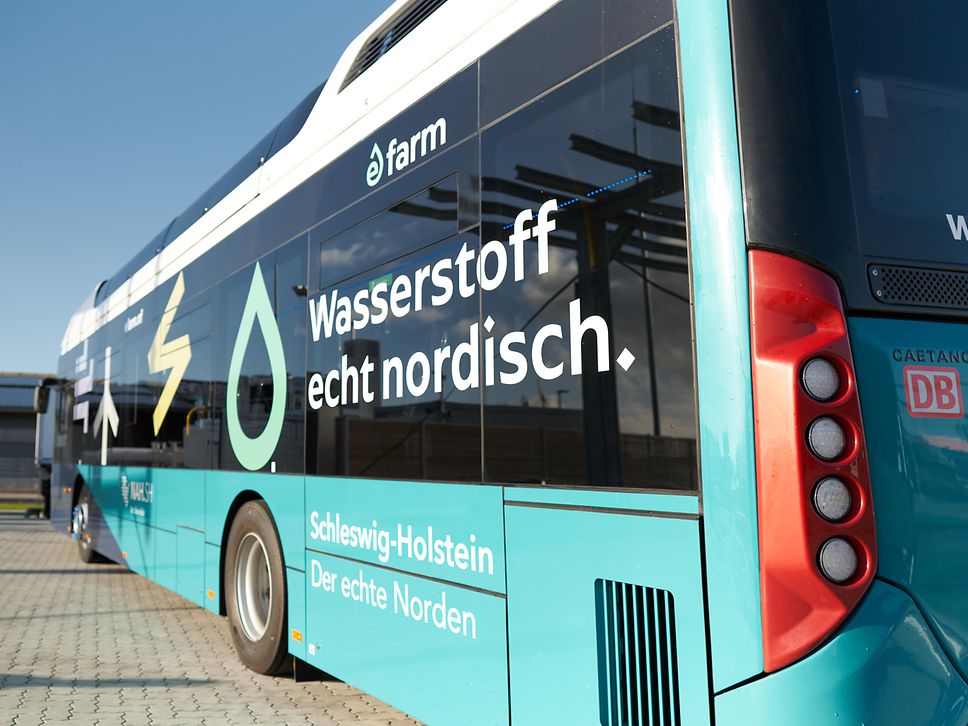 Ein türkiser Wasserstoffbus mit der Aufschrift Wasserstoff echt nordisch und dem Logo eFarm