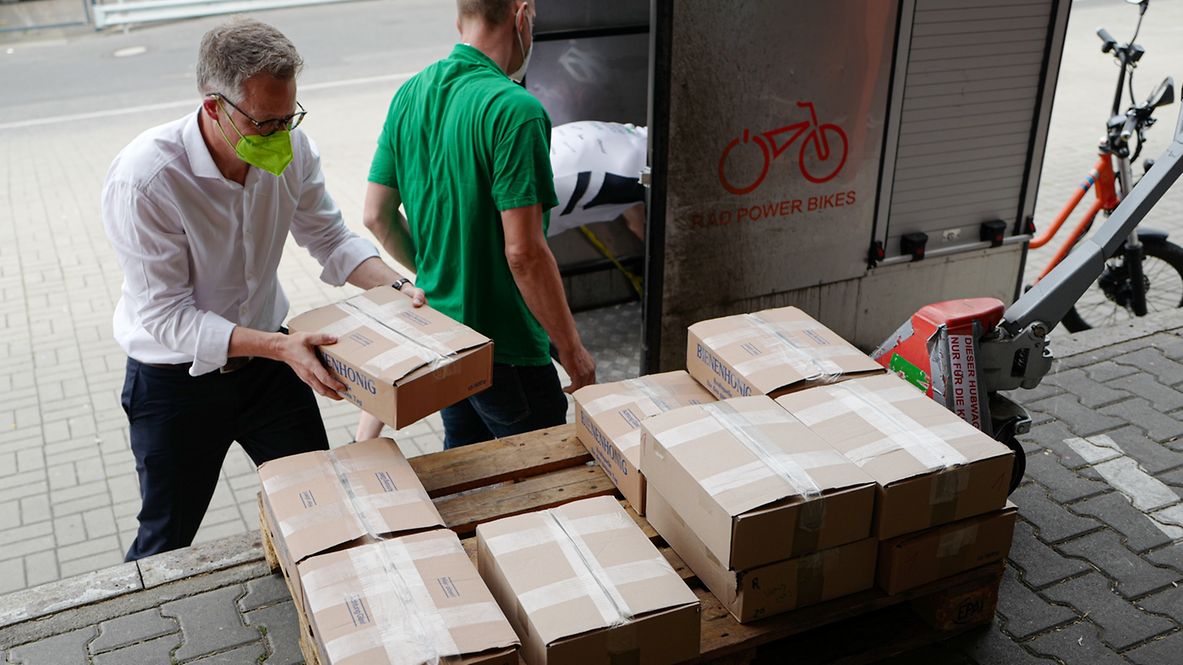 Zwei Männer packen Kisten.