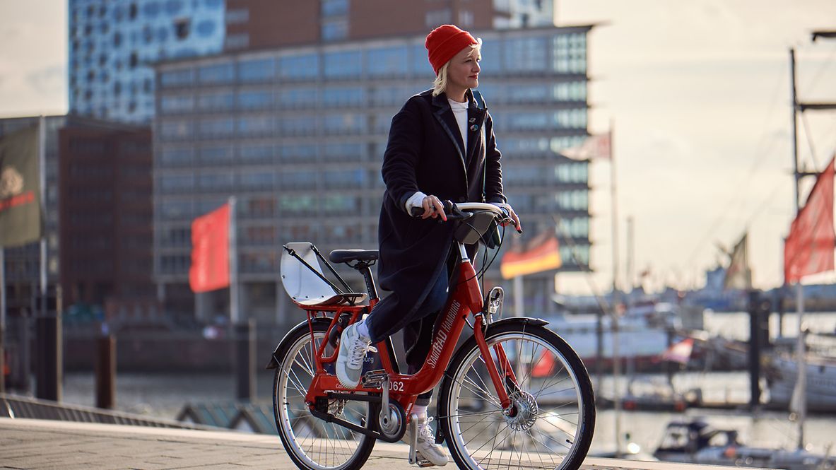 Frau fährt mit einem Fahrrad am Hamburger Hafen