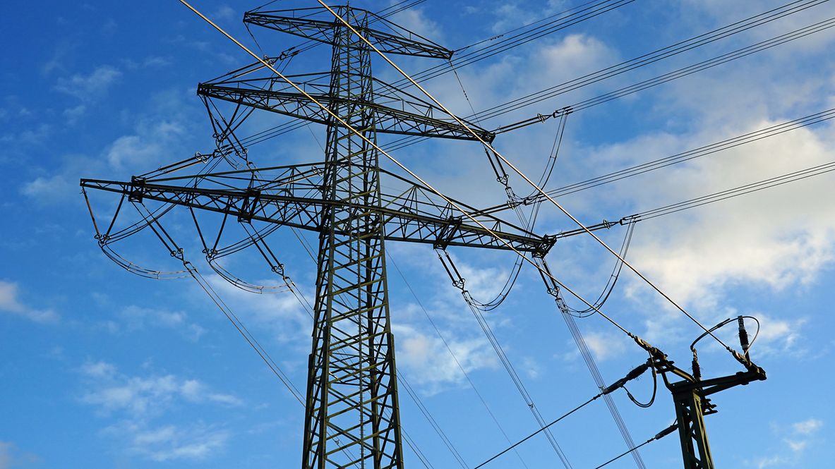 Strommast vor blauem Himmel