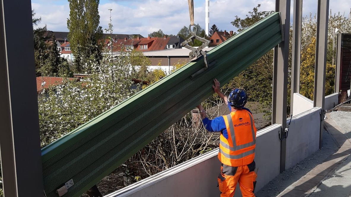 Ein Bauarbeiter bei der Errichtung einer Schallschutzwand