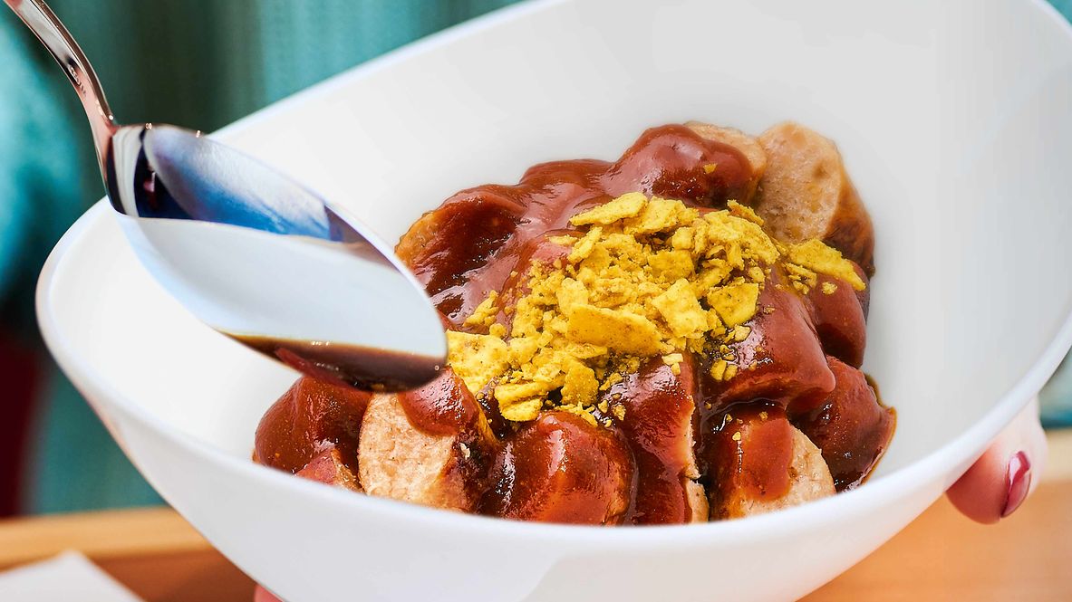 Eine Porzellanschüssel gefüllt mit veganer Currywurst