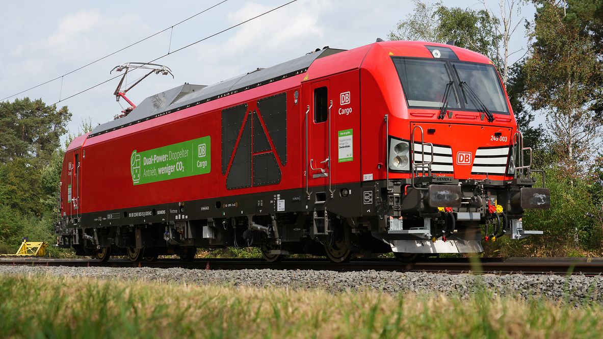 Eine rote DB Cargo-Lokomotive mit Dual-Power-Antrieb fährt auf Gleisen