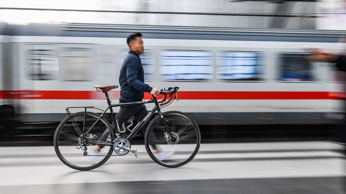 Ein Reisender mit Fahrrad am Bahnhof