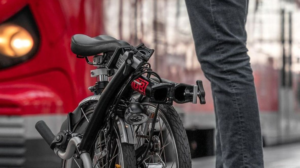 Ein Reisender mit Faltrad am Bahnsteig