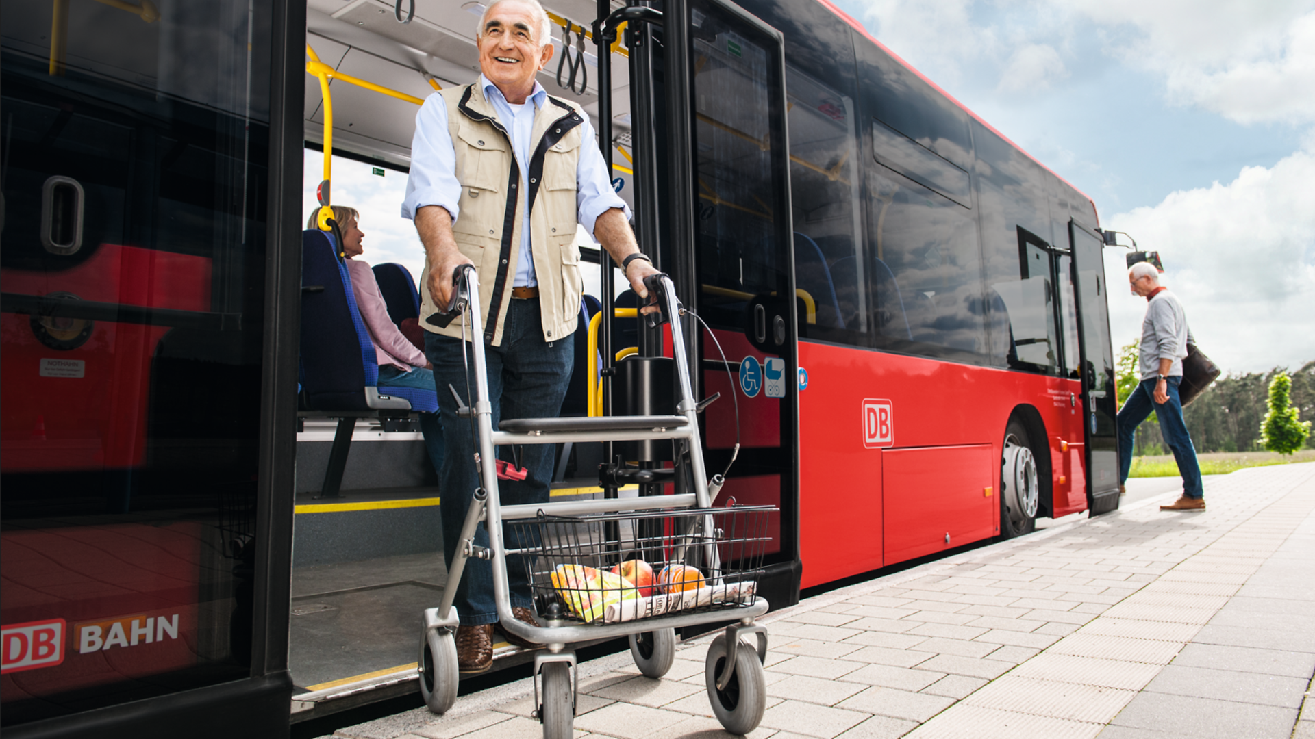 Ein älterer Herr steigt mit seinem Rollator aus einem niederflurigen Bus.