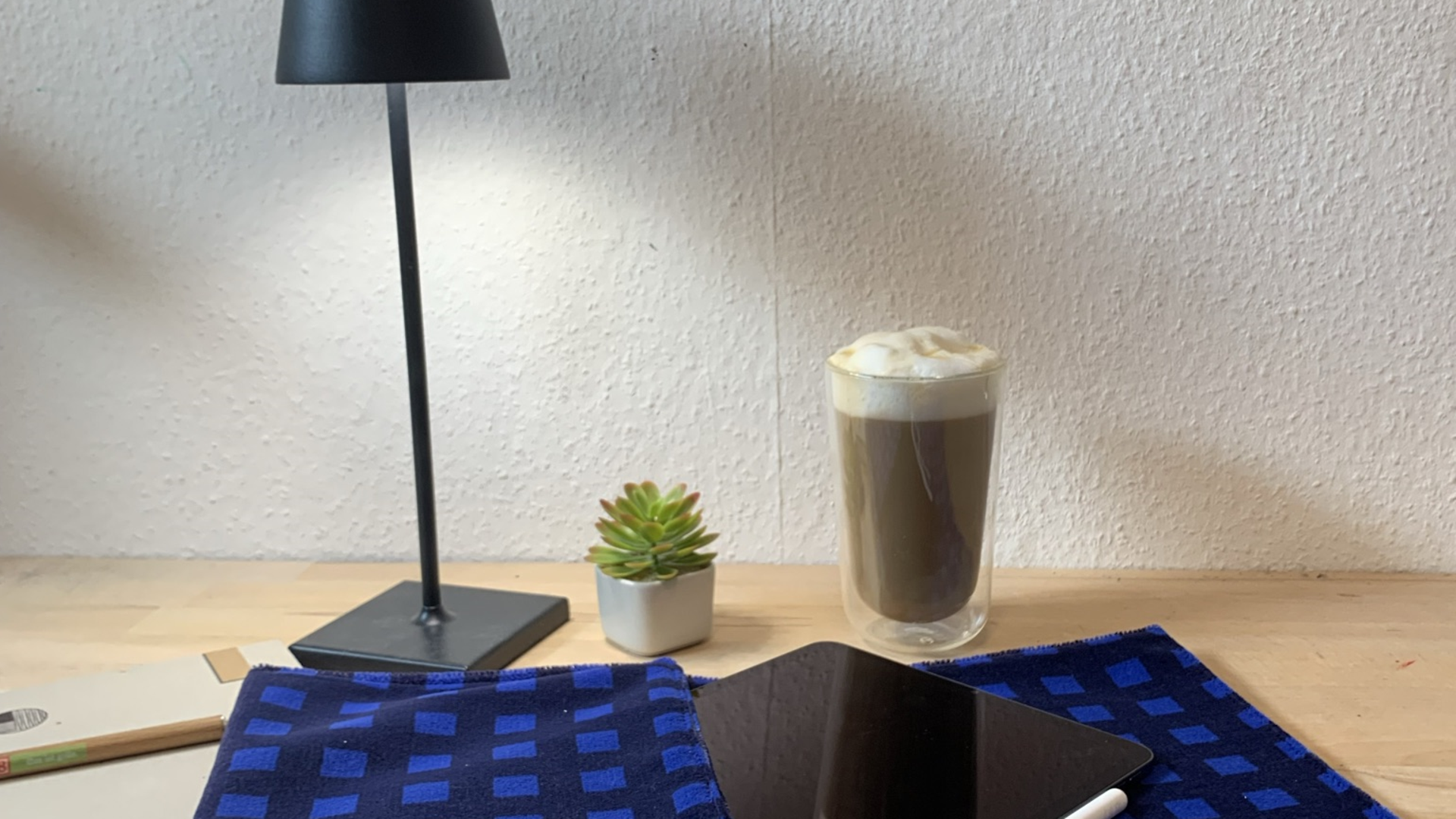 Schreibtisch, auf dem ein Tablet in einer Schutzhülle aus Materialien der DB Regio-Sitzbezüge liegt