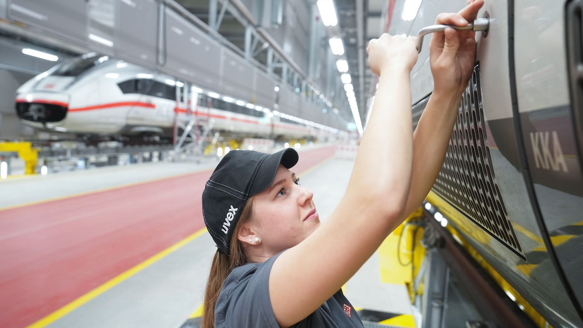 Eine junge DB-Mitarbeitende arbeitet im Cottbuser Instandhaltungswerk an einem ICE.