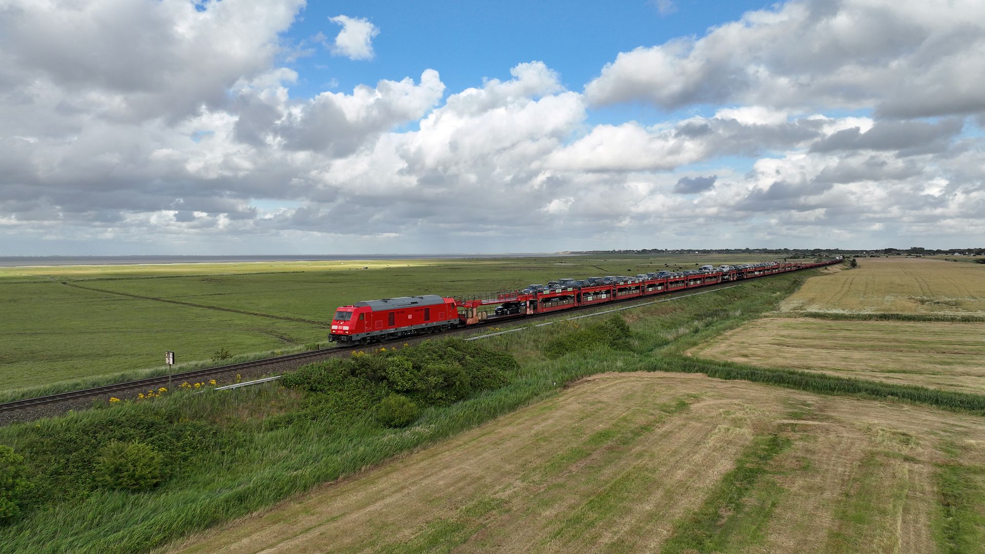 Sylt Shuttle unterwegs auf Schienen in Landschaft 
