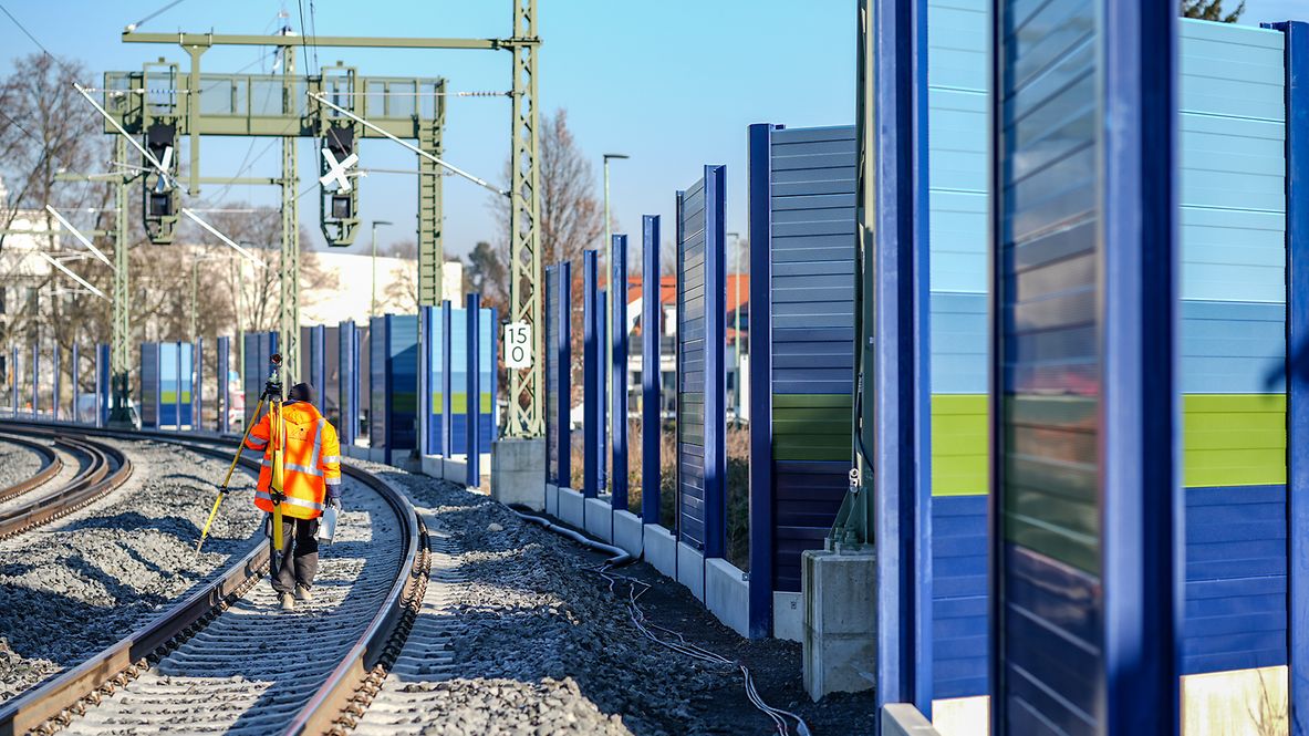 Ein Mitarbeiter der DB beaufsichtigt den Bau von Lärmschutzwänden