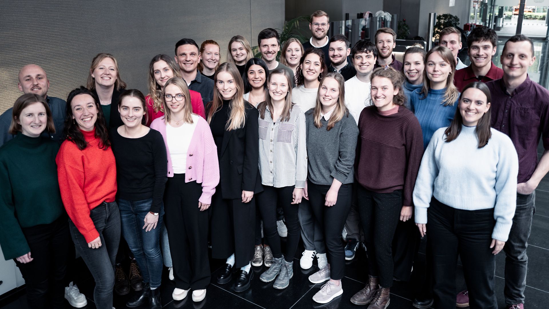 Große Gruppe junger Menschen, die für ein Gruppenbild zusammenstehen