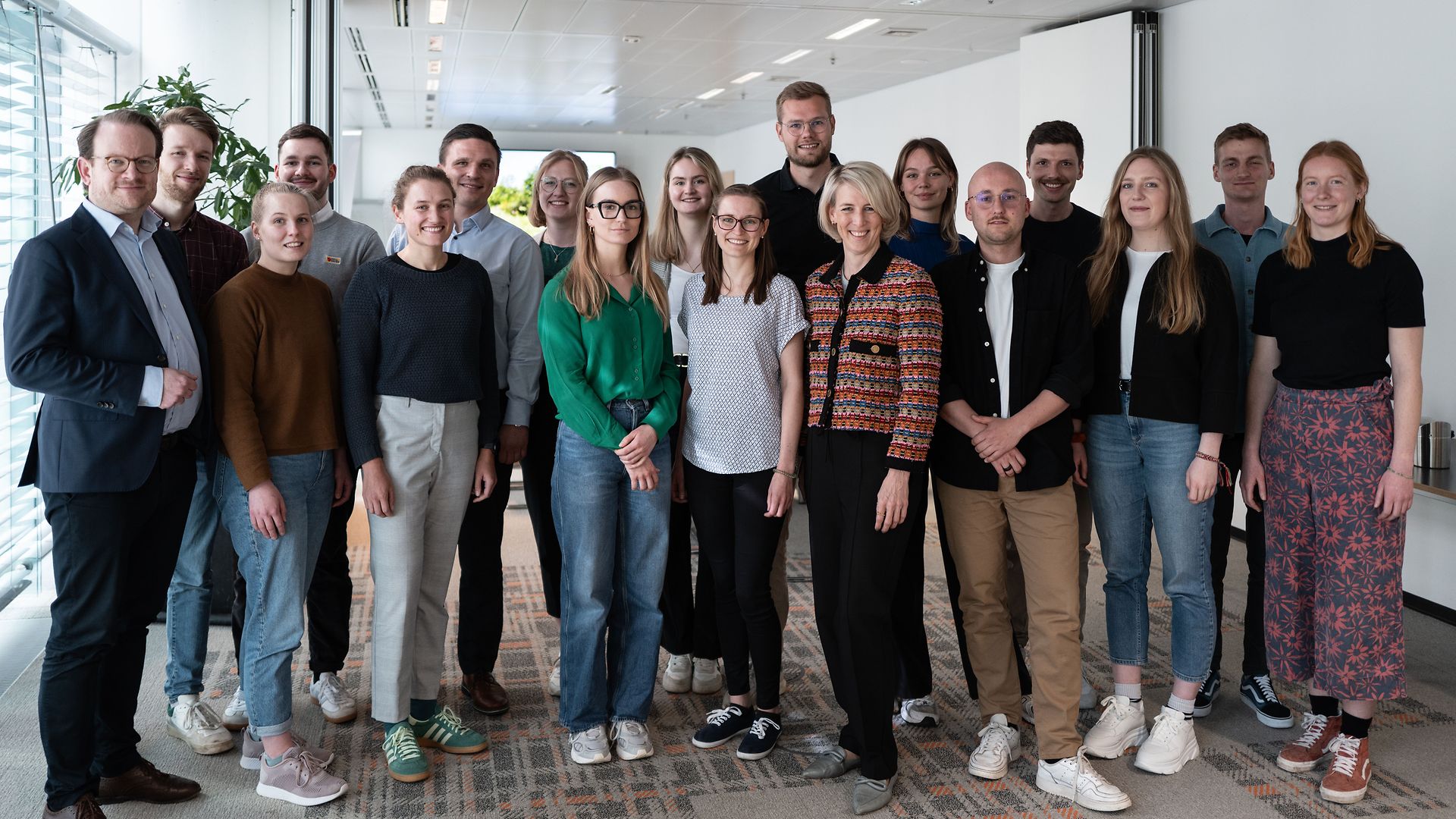 Sechzehn junge Menschen, die zusammen mit Führungskräfeten des Bereichs Nachhaltigkeit für ein Gruppenbild zusammenstehen
