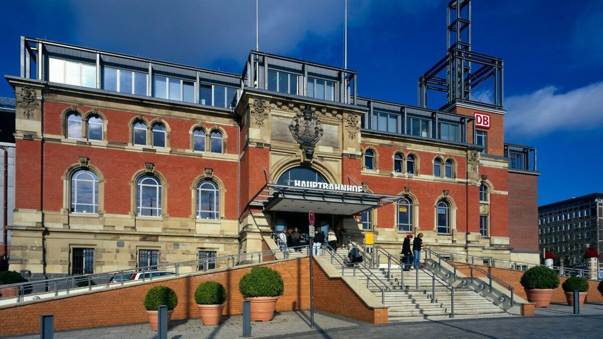 Blick auf das Empfangsgebäude des Kieler Hauptbahnhofs im Sonnenschein.