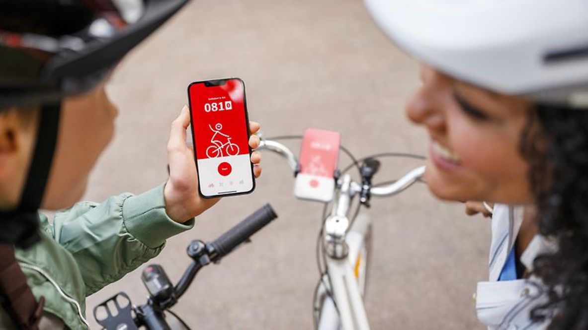 Zwei Menschen auf Fahrrädern nutzen die DB Rad+ App.