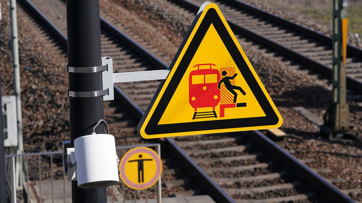 Nahaufnahme eines Warnschildes neben den Gleisen