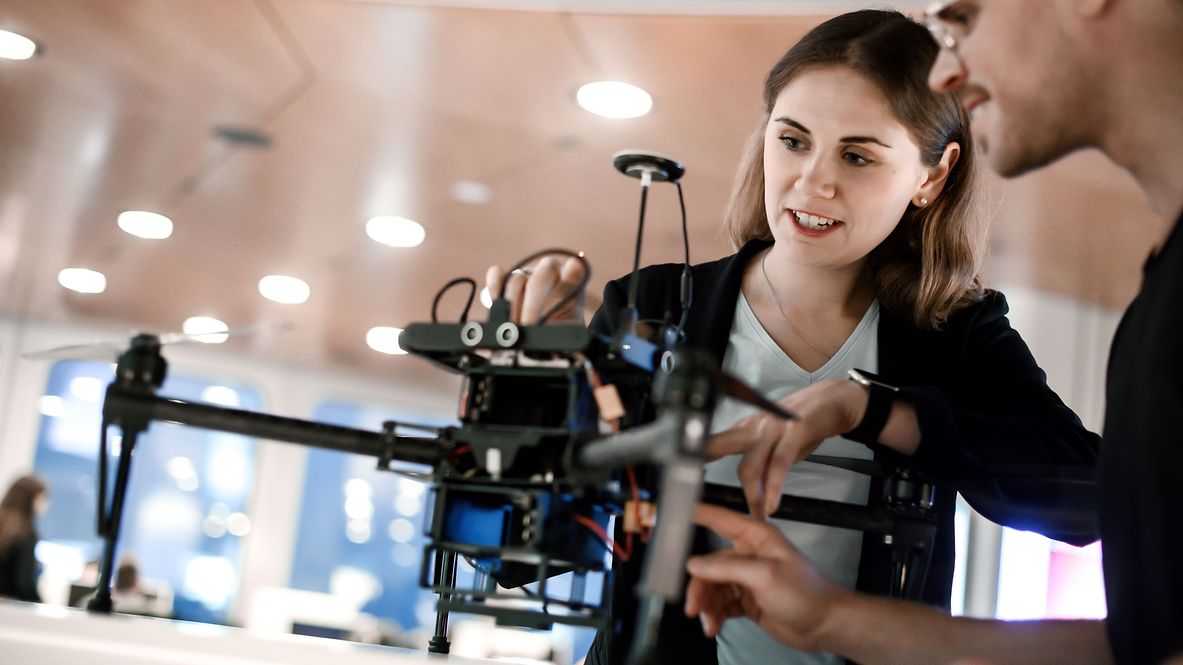 Mitarbeitende von DB Systel begutachten eine Drohne.