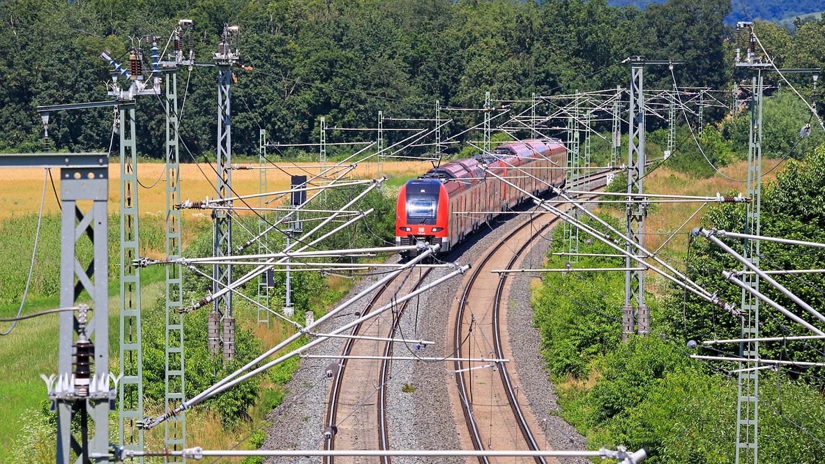 Ein Zug fährt unter einer Oberleitungsanlage.