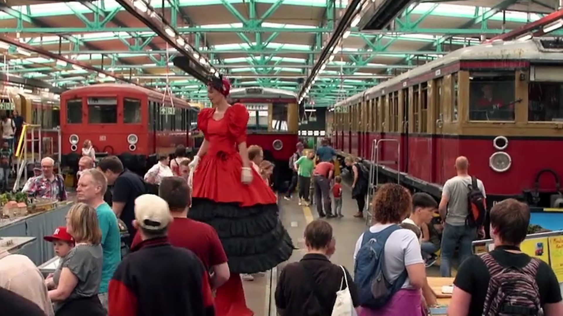 Historische S-Bahnen und Besucher:innen in einem S-Bahnwerk