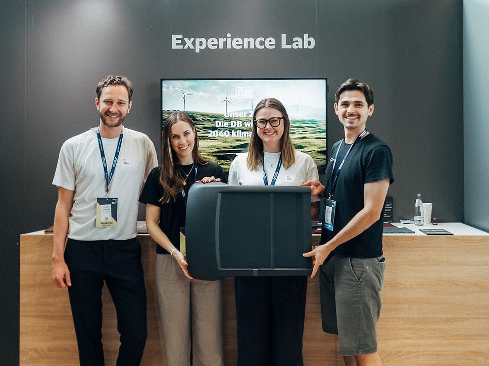 Mitarbeitende der Carbonauten GmbH präsentieren eine Sitzschale aus einem Kunststoff.