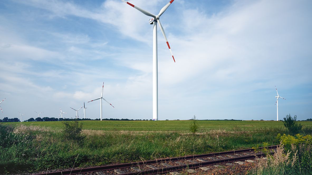 Wind turbines in a field beside a rail line