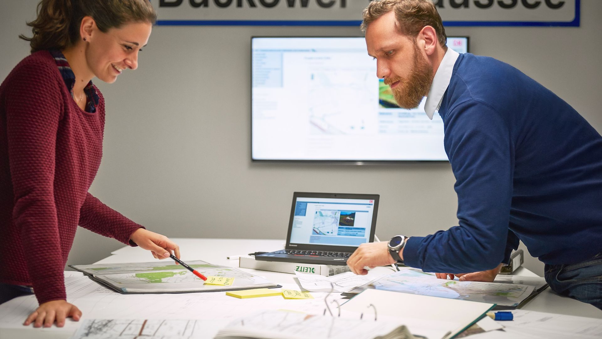 Two employees are consulting at a desk.