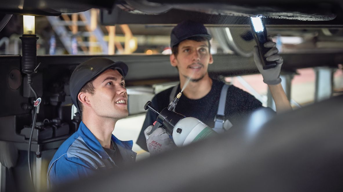 Two employees are loading a train with eco-friendly products.