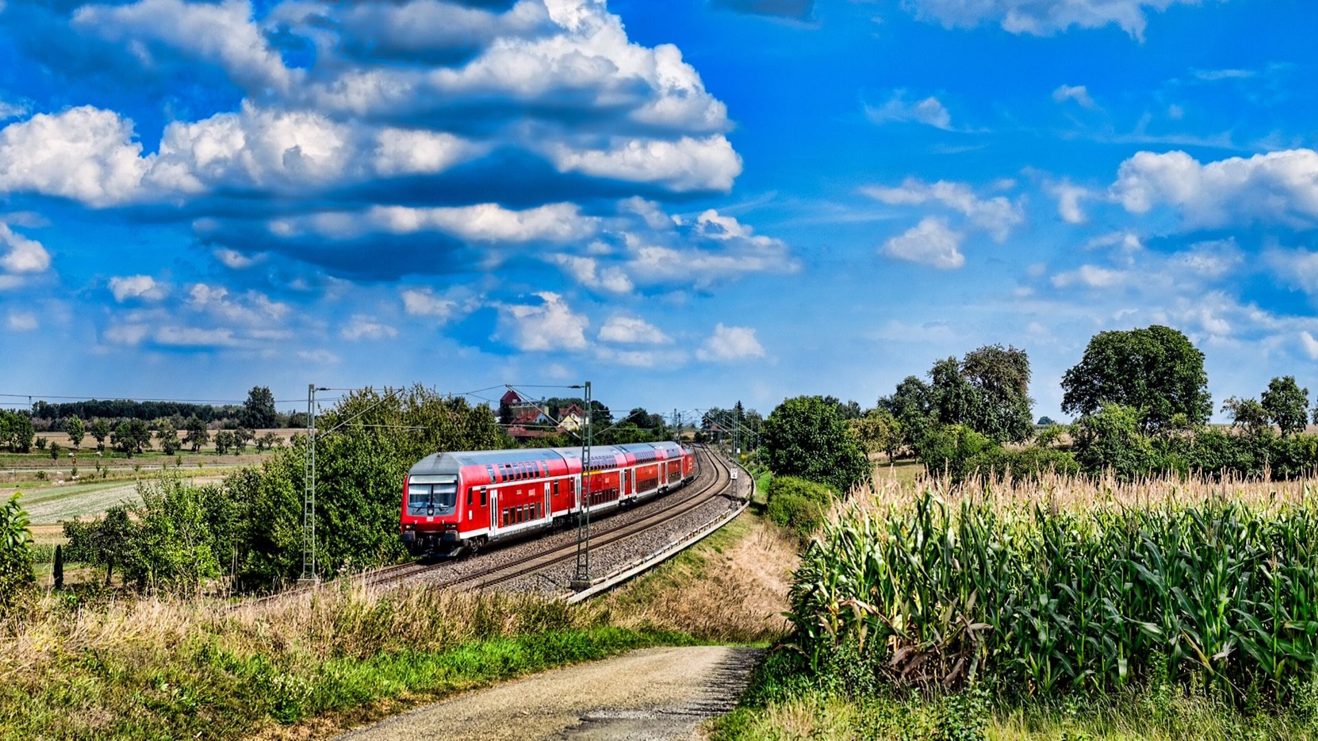 A Deutsche Bahn train travels through fields and countryside. 