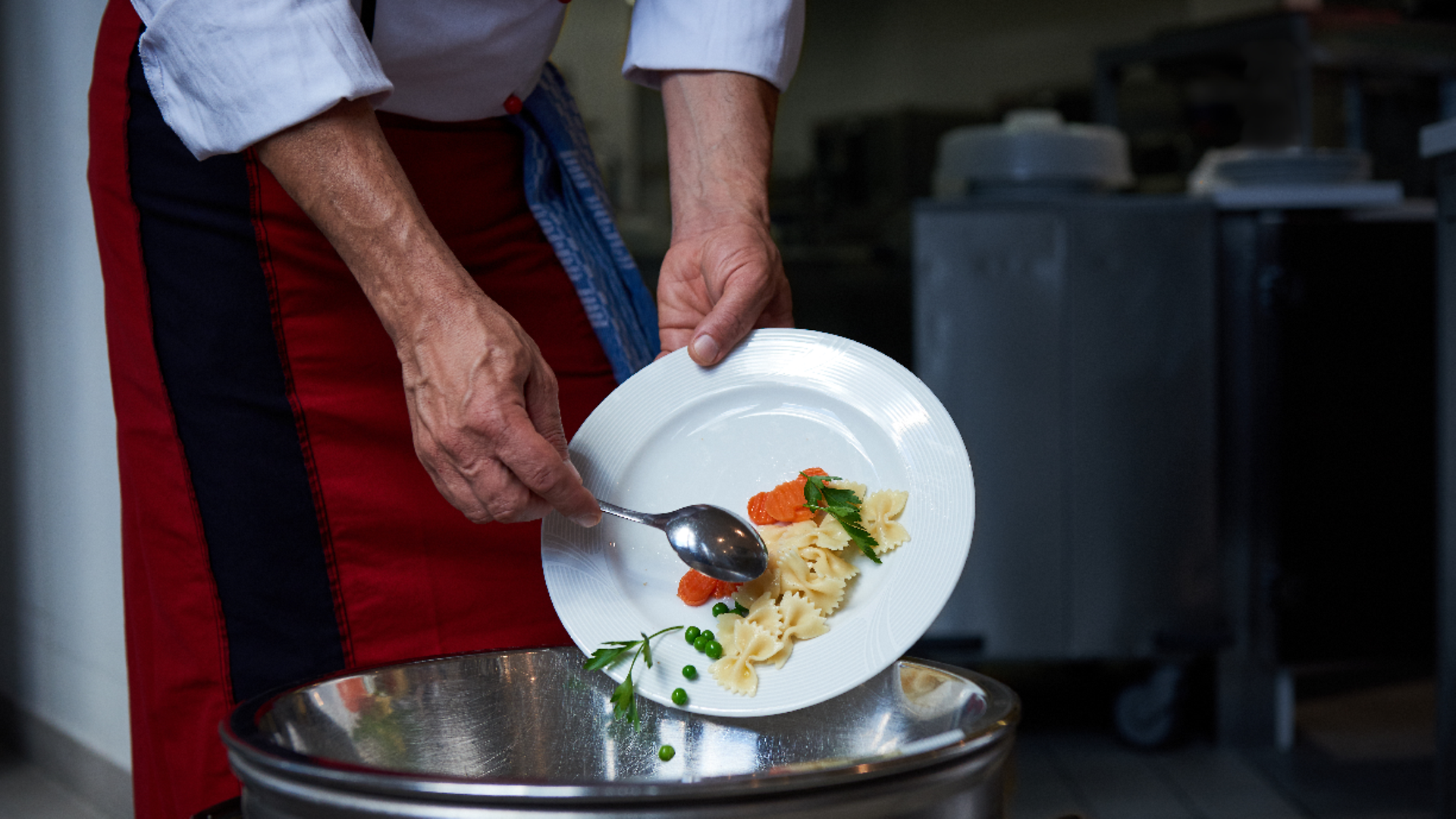 Food scraps are thrown from a plate into waste garbage can.