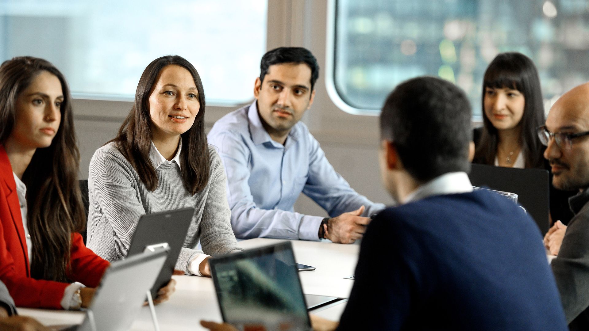 Employees are sitting at a conference table and talking.