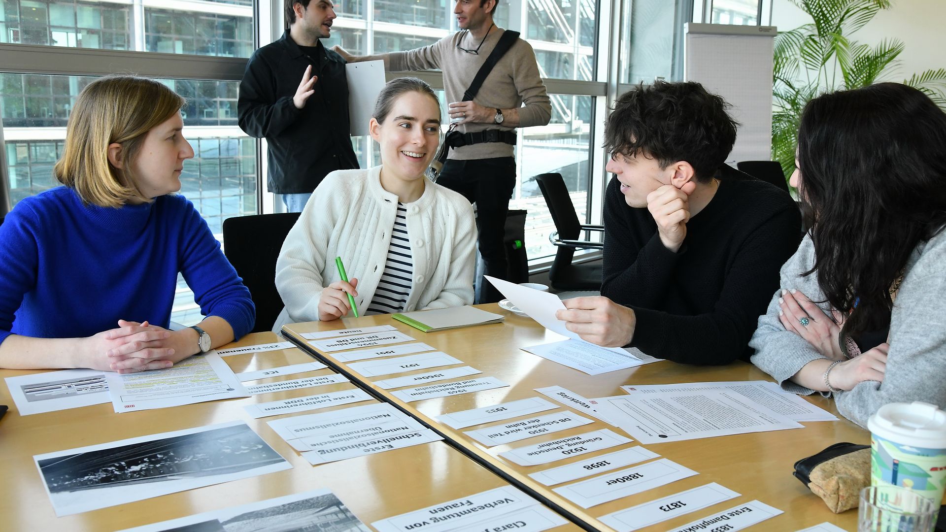 A group of trainees is working together on a desk.