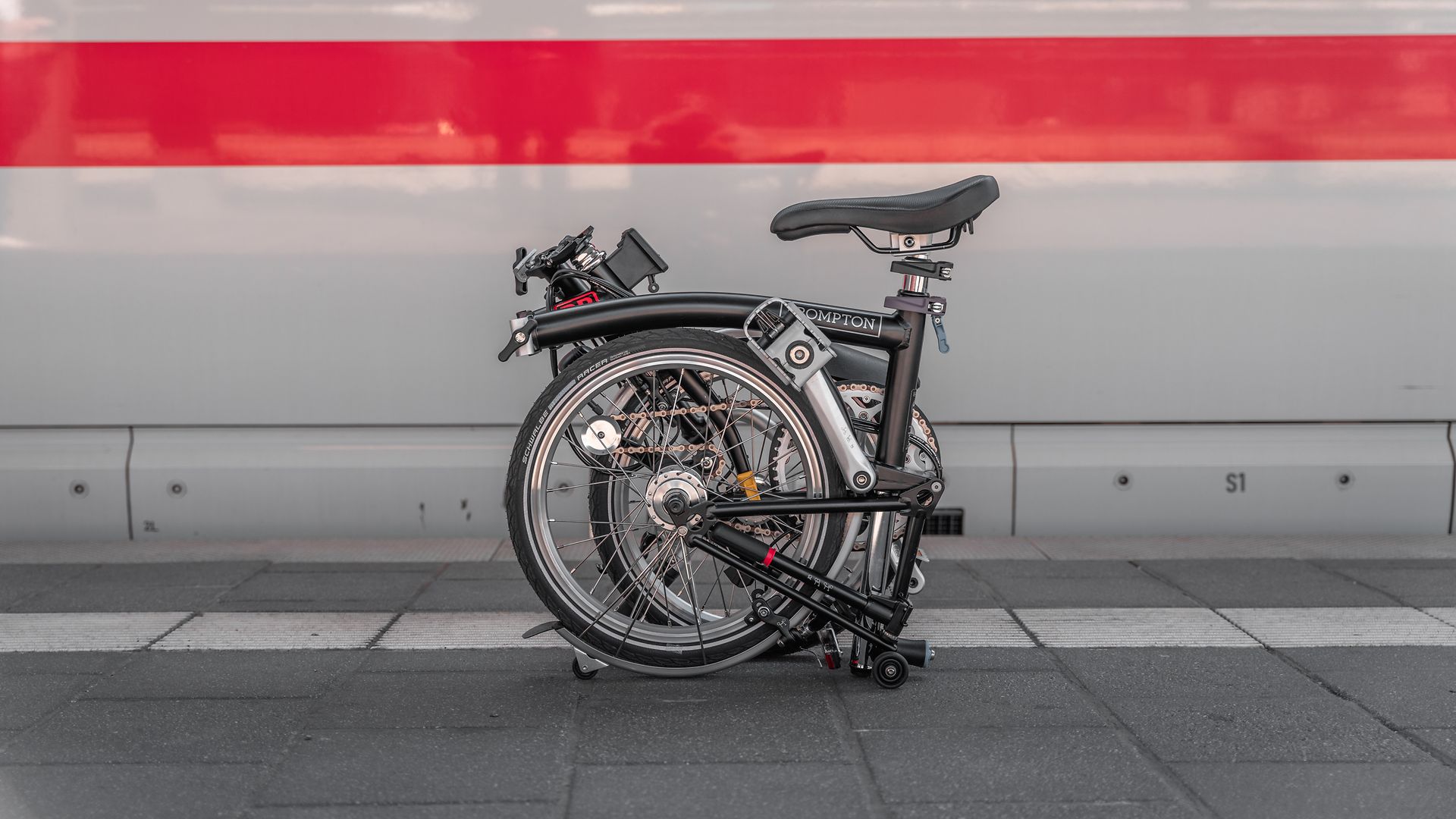 A folded folding bike in front of an ICE train