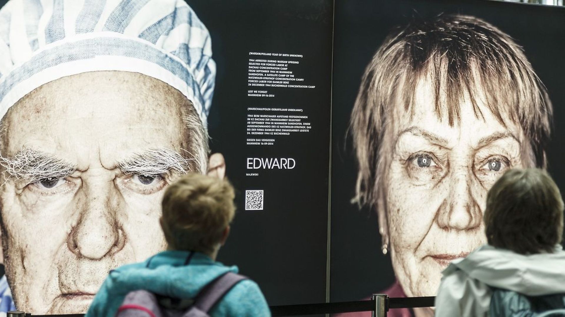 A person looks at a poster announcing an exhibition.