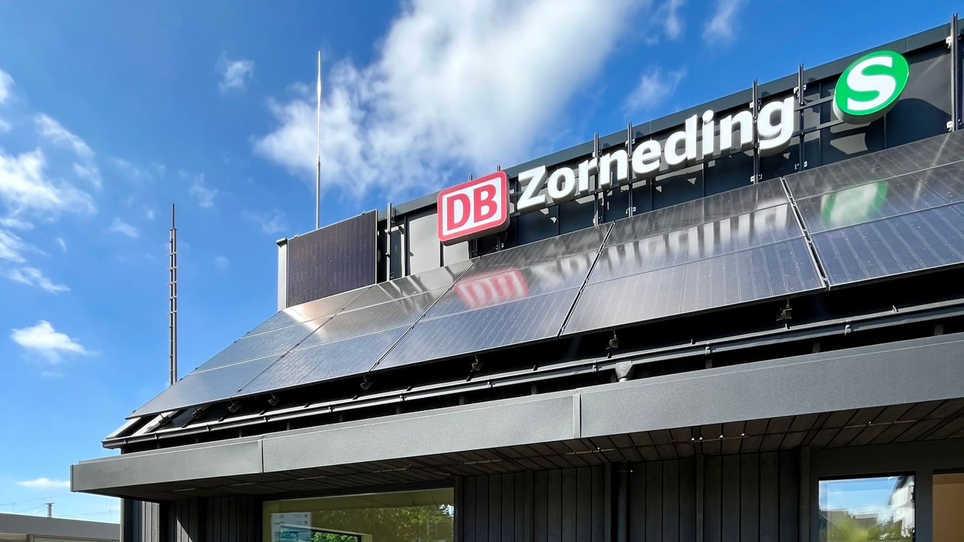 Front view of the passenger building in Zorneding with large windows and bench