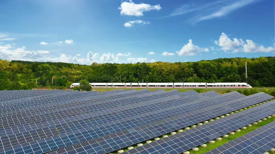 Ein ICE der Deutschen Bahn fährt an einem Solarpark vorbei