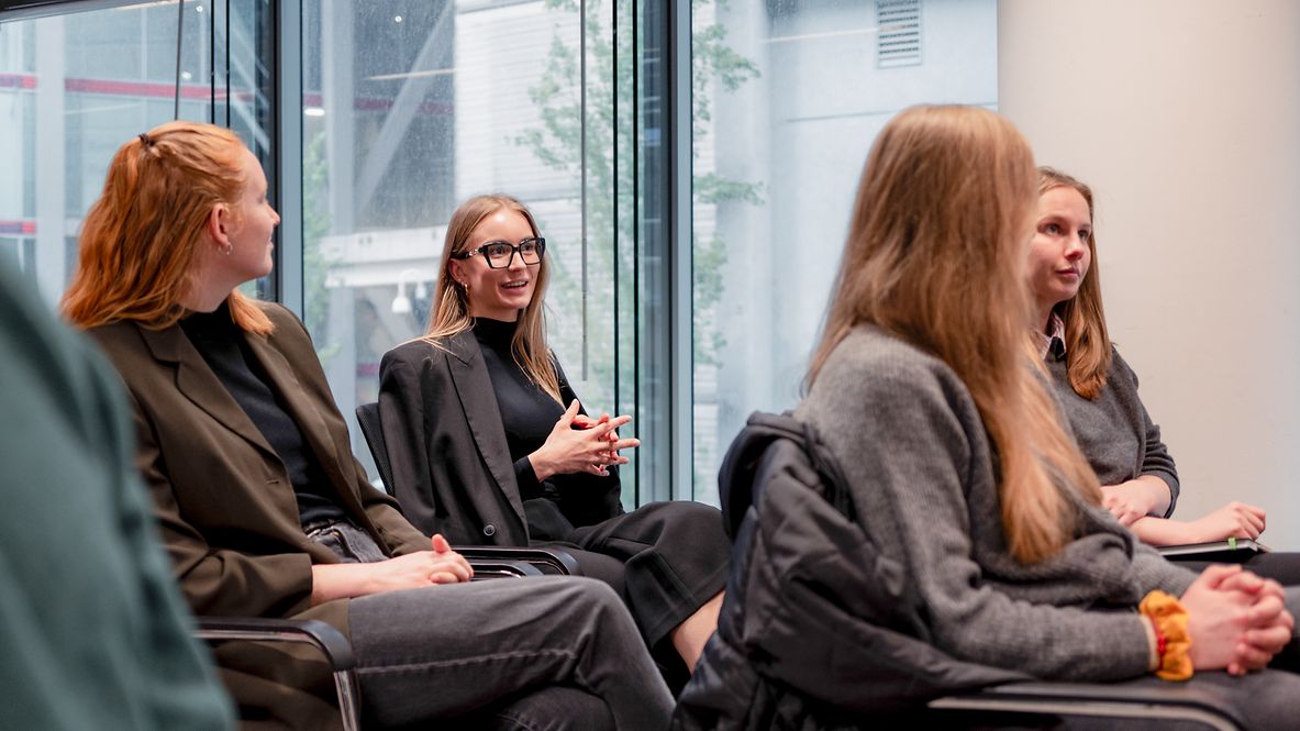 Teilnehmende des Traineeprogramms Nachhaltigkeit der Deutschen Bahn sitzen in einem Konferenzraum.